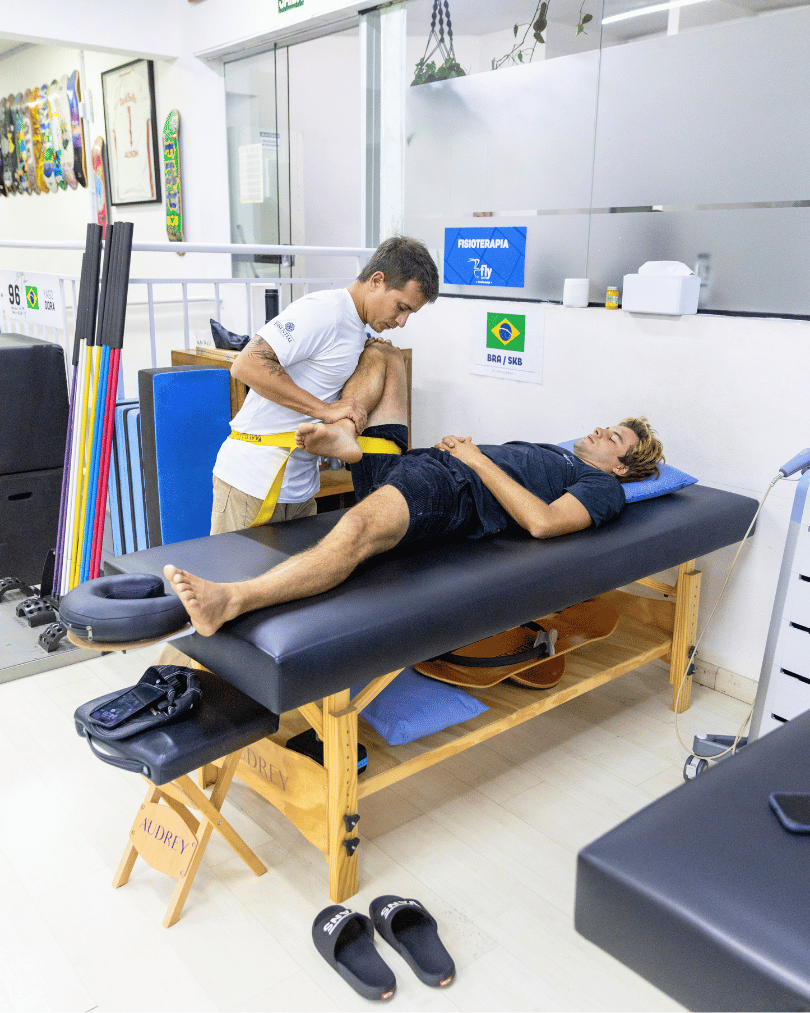 Fisioterapeuta Leo Assis fazendo atendimento no surfista Mateus Herdy
